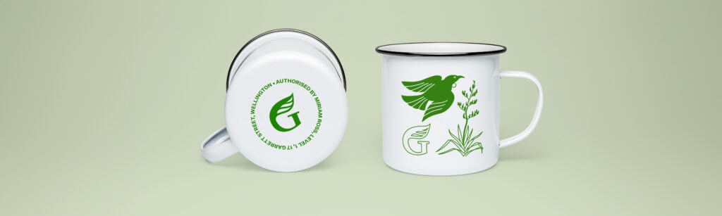 NZ Greens tūī merchandise artwork on enamel mugs